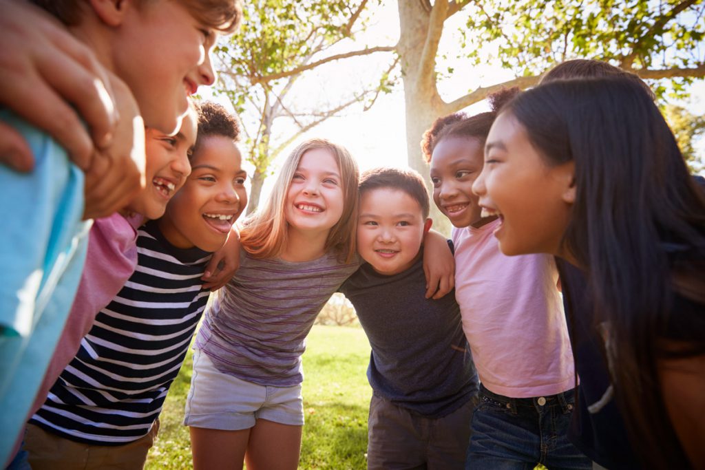 Nonprofit Kids playing in a huddling under the Sun.